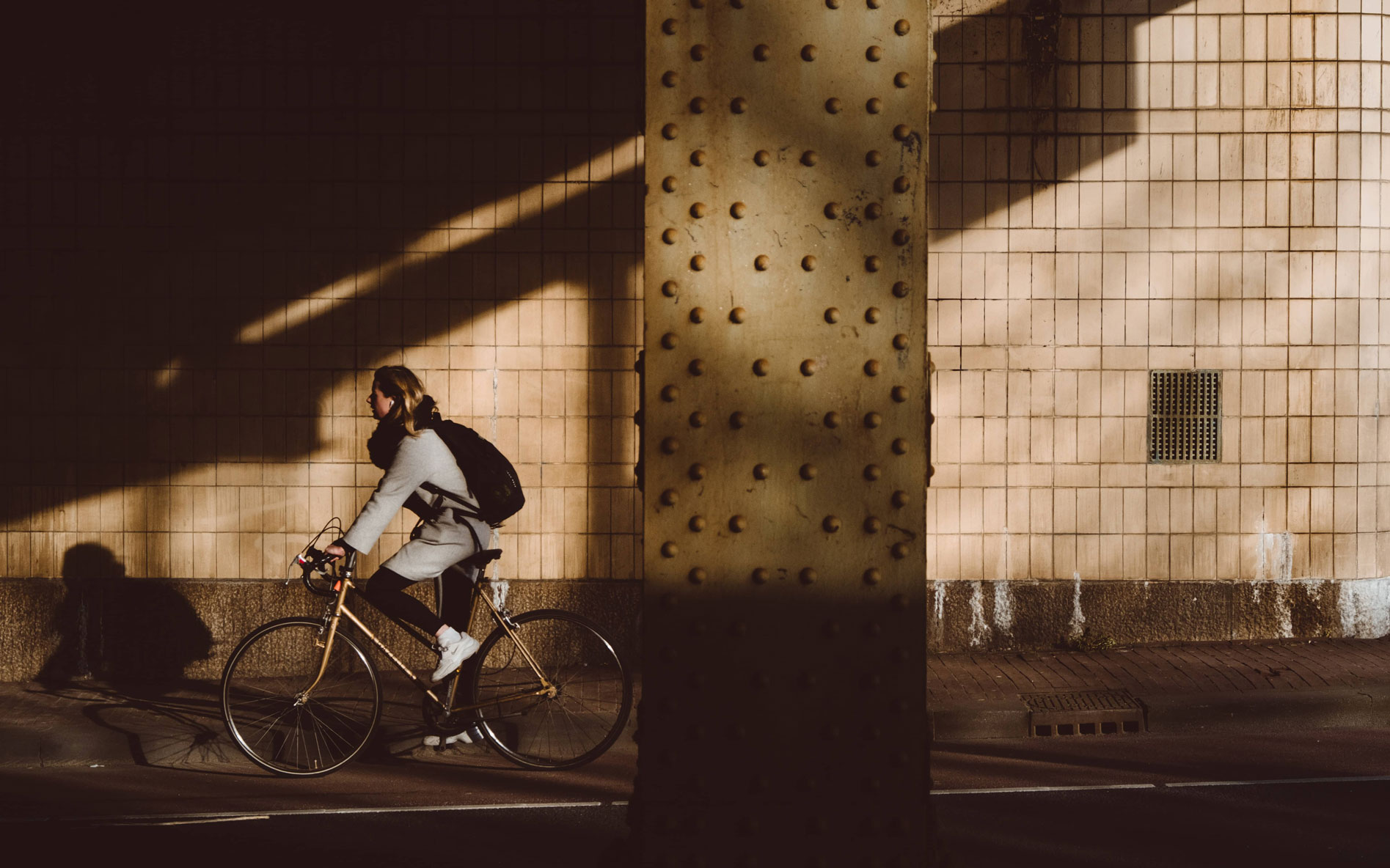 Woman cycling under a bridge