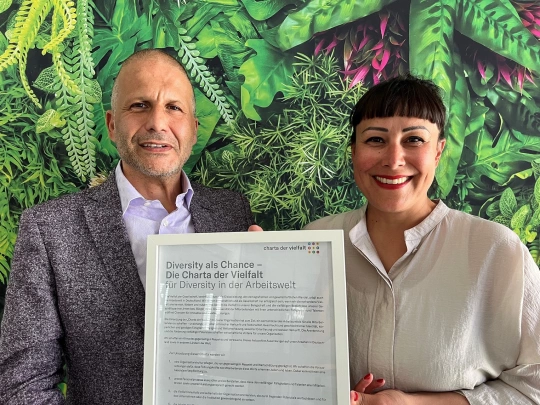 Dr Ernesto Marinelli at the left, Aareon Management Board member responsible for People & Culture, and at the right Sandra Hendro, Chief Diversity, Equity & Inclusion Officer at Aareon, hold the signed Diversity Charter in their hands.