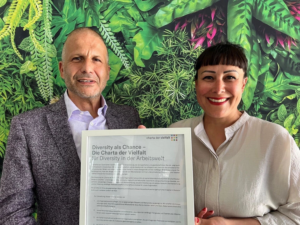 Dr. Ernesto Marinelli, links und Sandra Hendro, beide Aareon, rechts, halten die unterzeichnete Charta der Vielfalt.